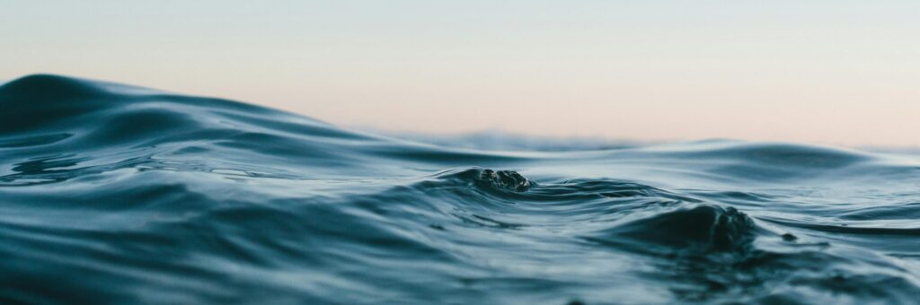 Tranquil ocean waves under a soft sunset sky, perfect for backgrounds.