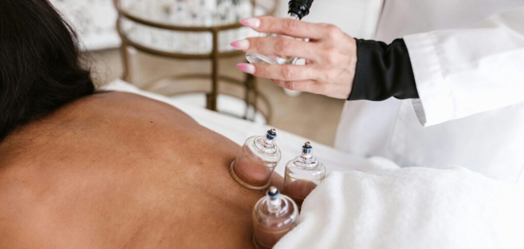 A woman receiving cupping therapy in a serene spa setting to relieve pain and stress.